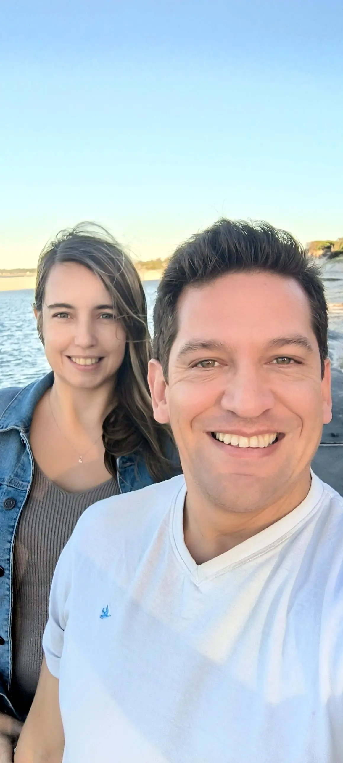 El equipo de +Simple sonriendo frente a la costa de Montevideo